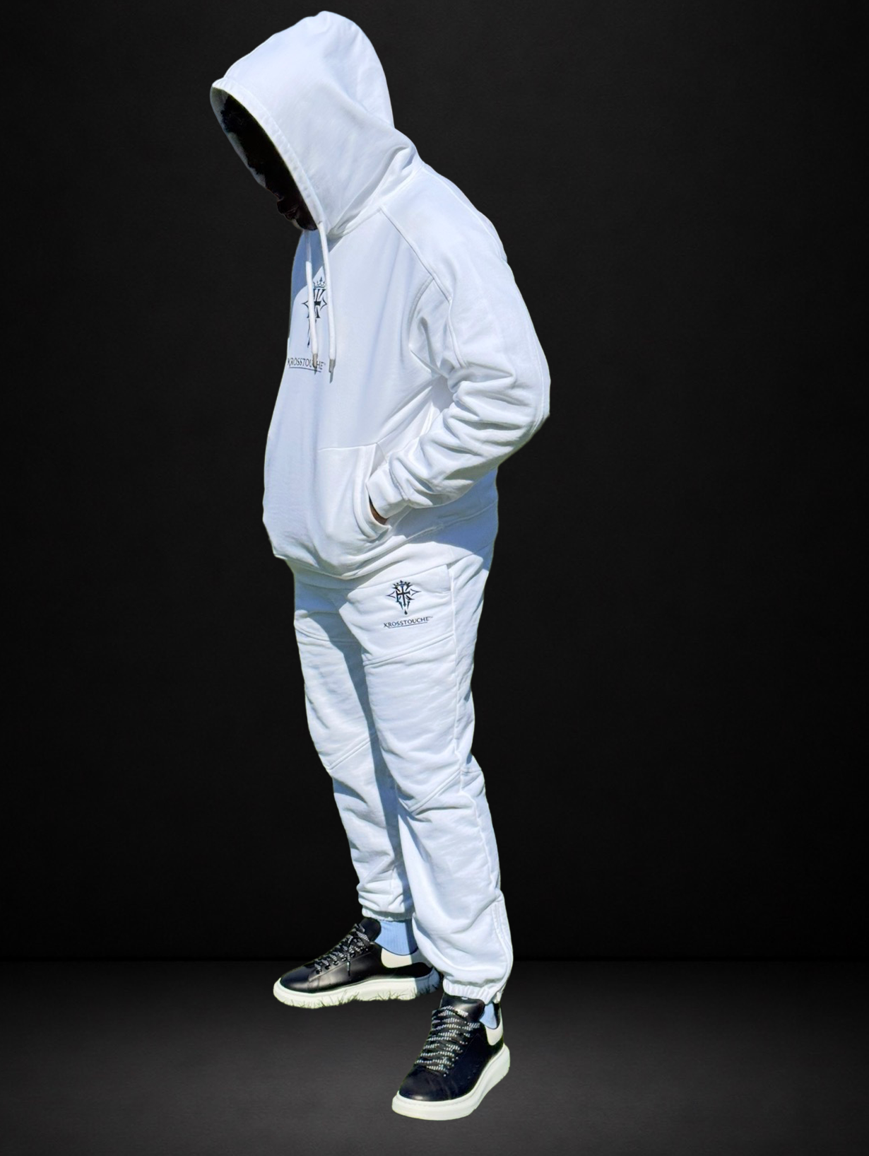 Side profile of a model wearing the KROSSTOUCHE® Providence hoodie and panelled joggers in optic white