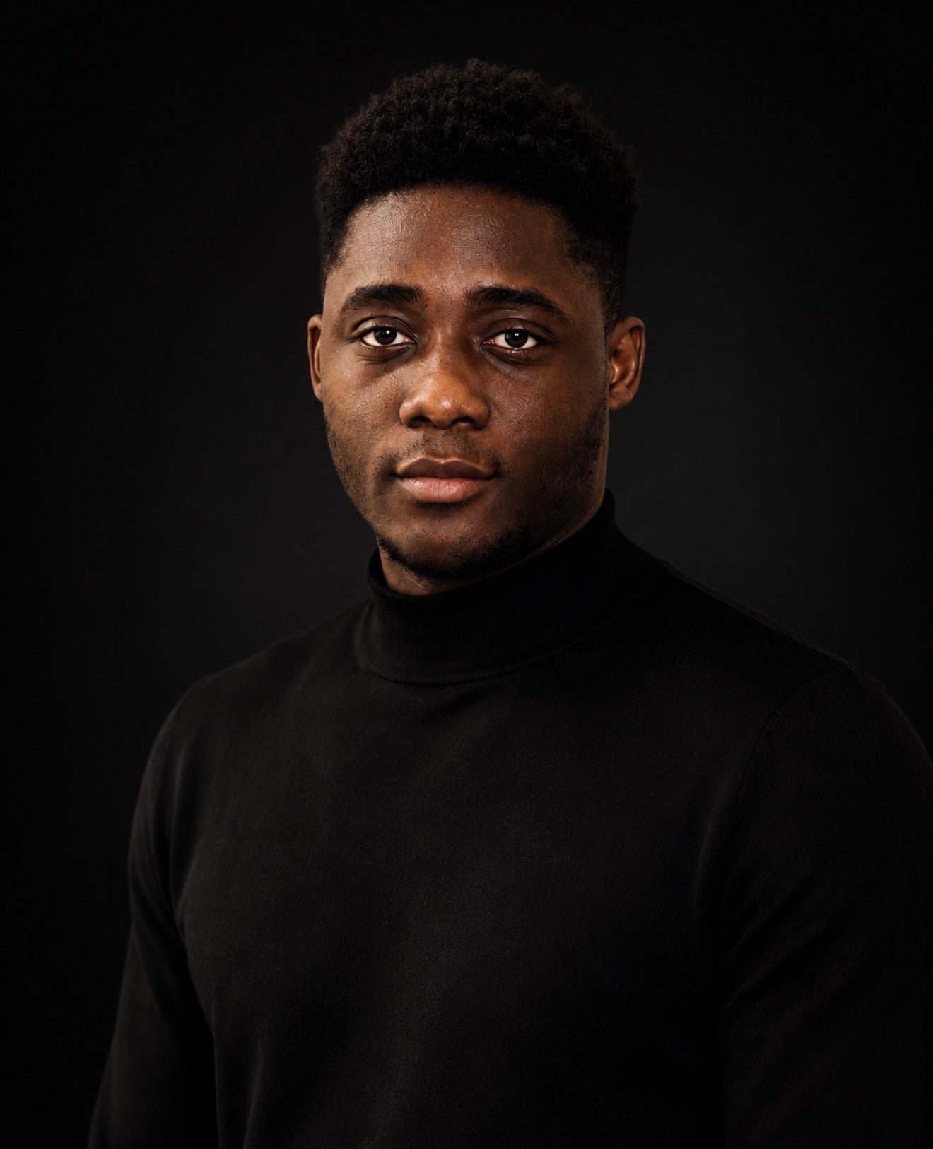 KROSSTOUCHE® founder Johnson wearing a black turtleneck, photographed against a black studio background.