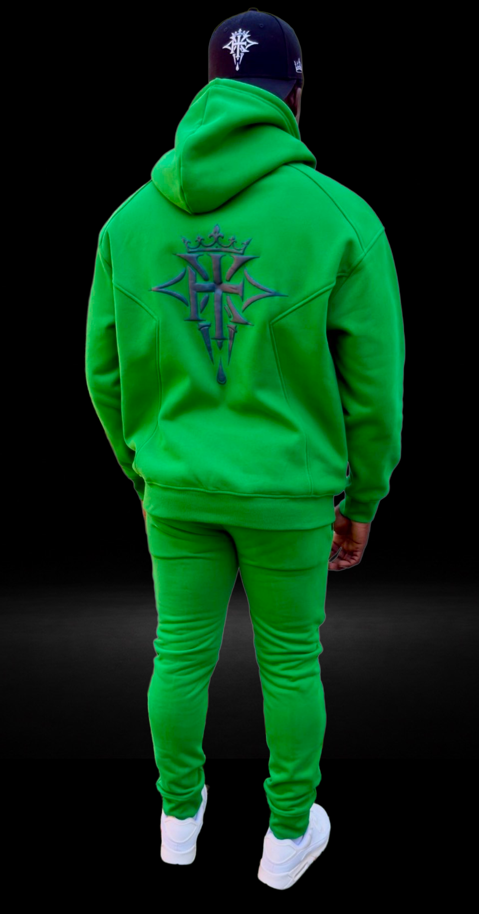 Back view of a male model wearing the KROSSTOUCHE® Sovereign Emerald hoodie and matching joggers, featuring the large embroidered crest on the back.