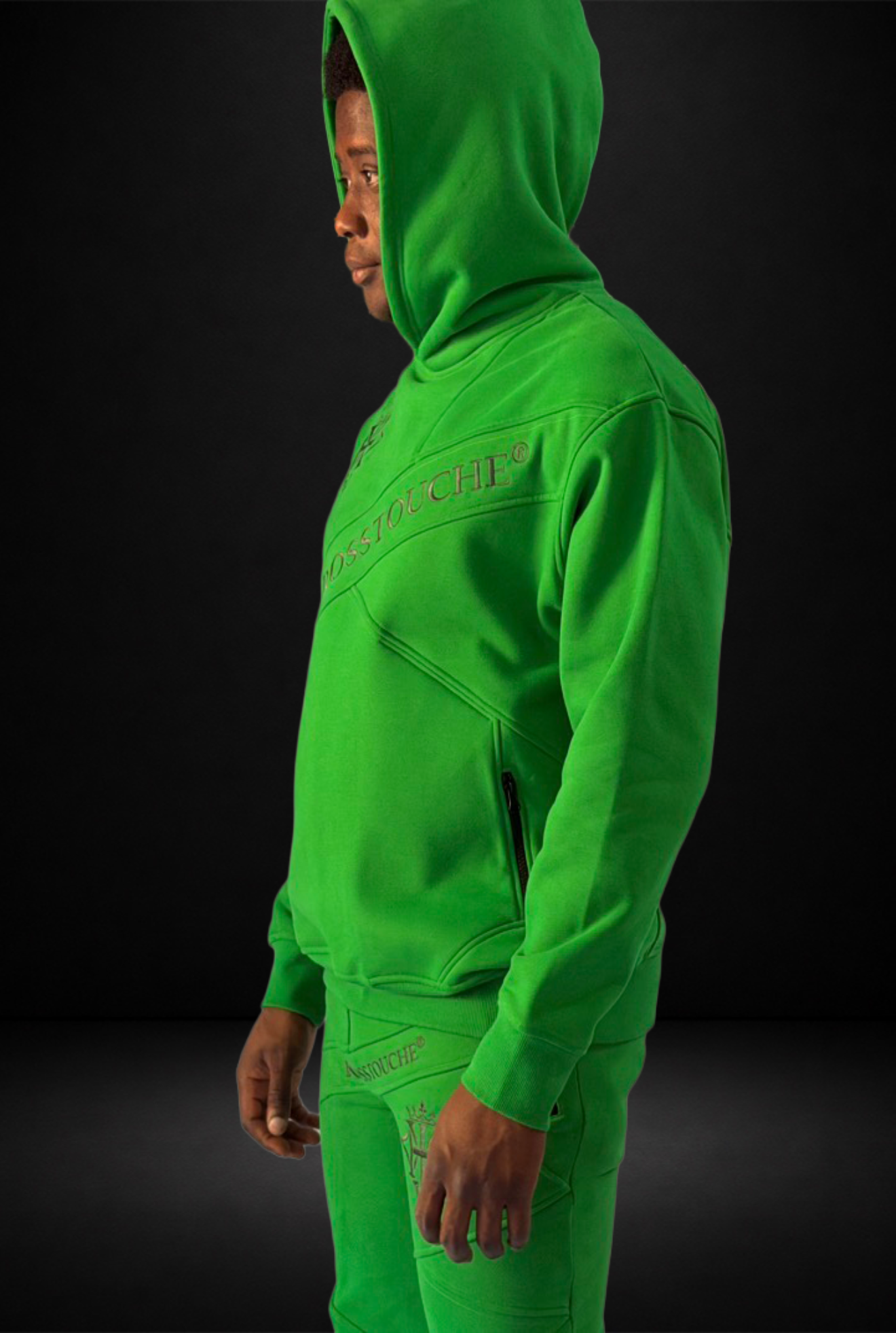 Model wearing the KROSSTOUCHE® Sovereign Emerald hoodie and joggers in a side-view studio photograph.